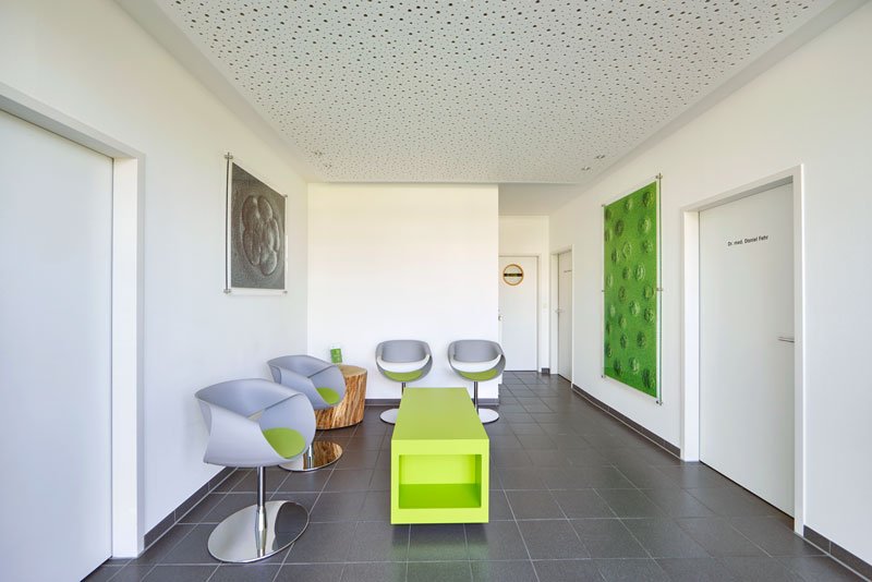 Vriendelijke wachtruimte van de Green-IVF praktijk met stijlelementen in de praktijkkleur groen