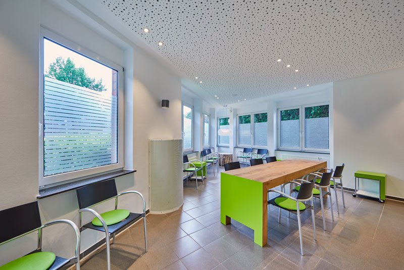 Vriendelijke wachtruimte van de Green-IVF praktijk met stijlelementen in de praktijkkleur groen